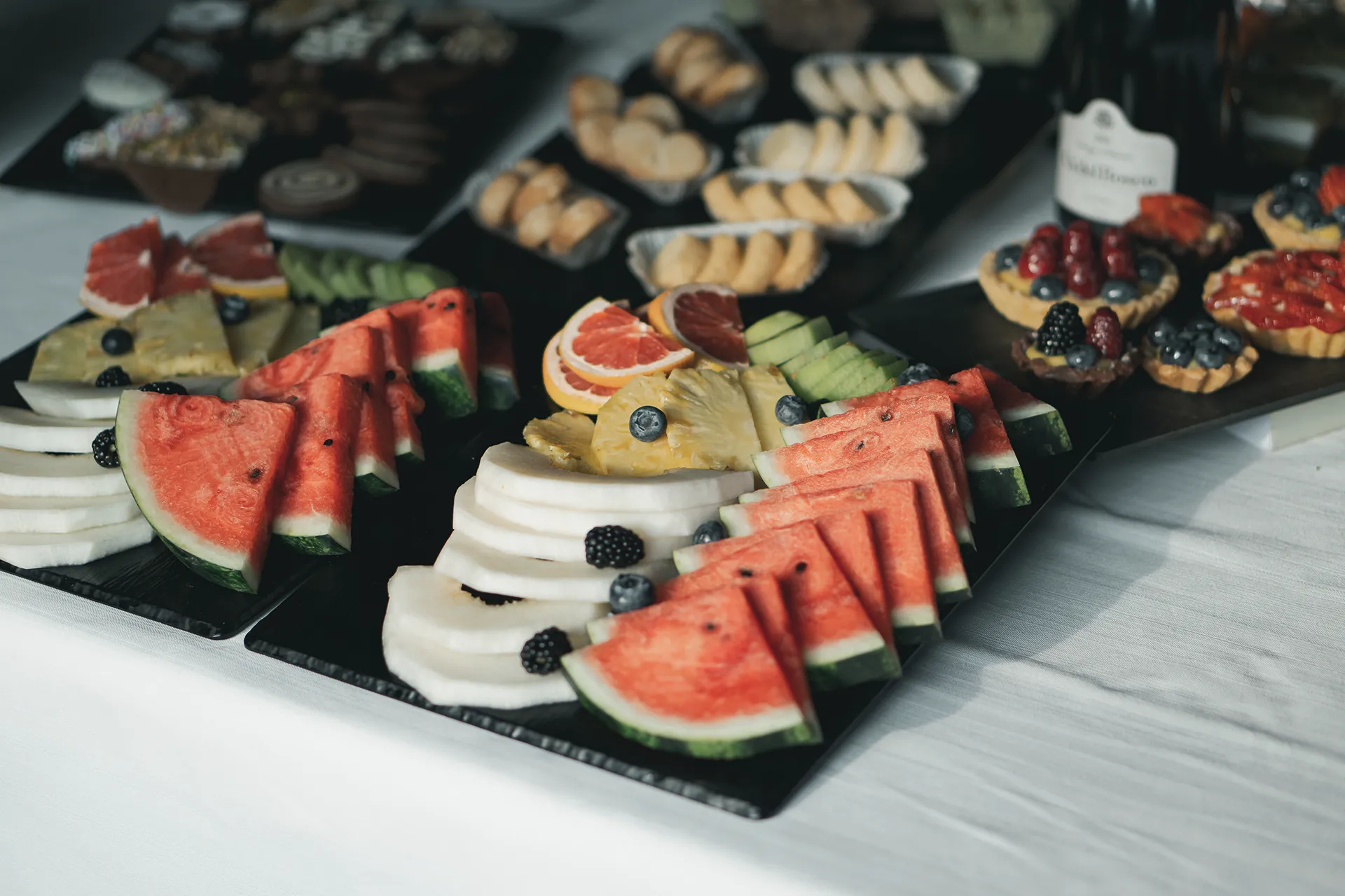 Frutta fresca affettata accompagnata da pasticceria secca e crostatine alla frutta