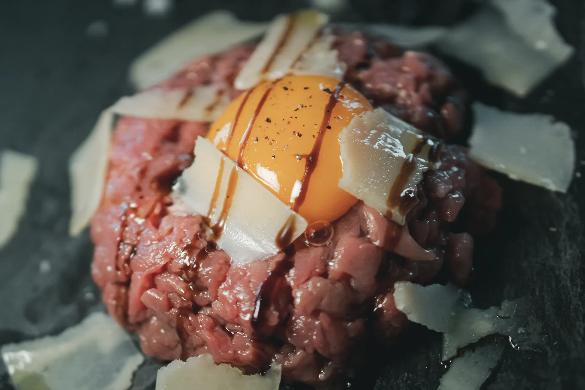 Tartarre di manzo con tuorlo d'uovo, scaglie di grana e pepe