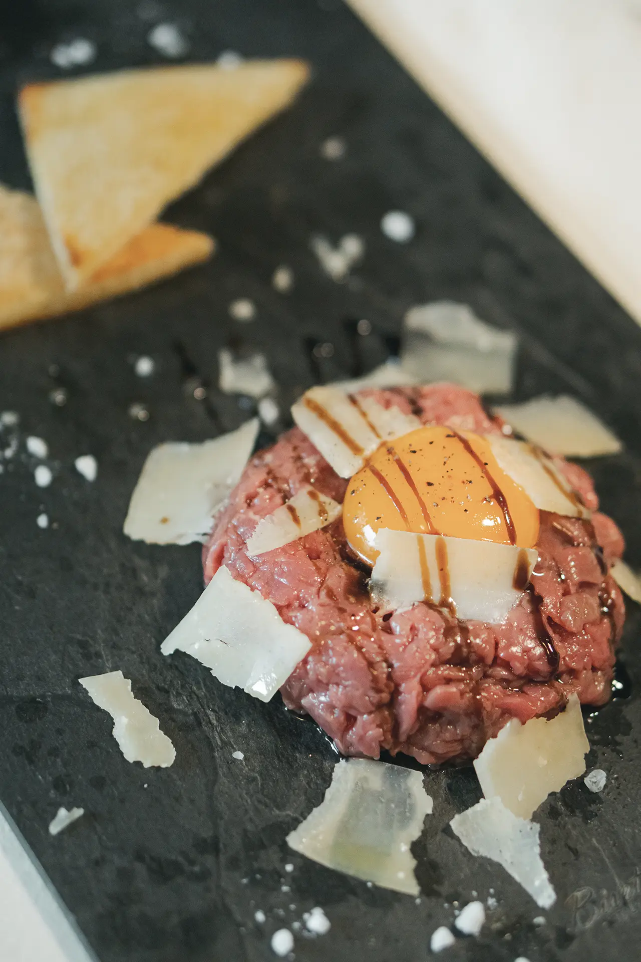 Tartarre di manzo con tuorlo d'uovo, scaglie di grana e pepe