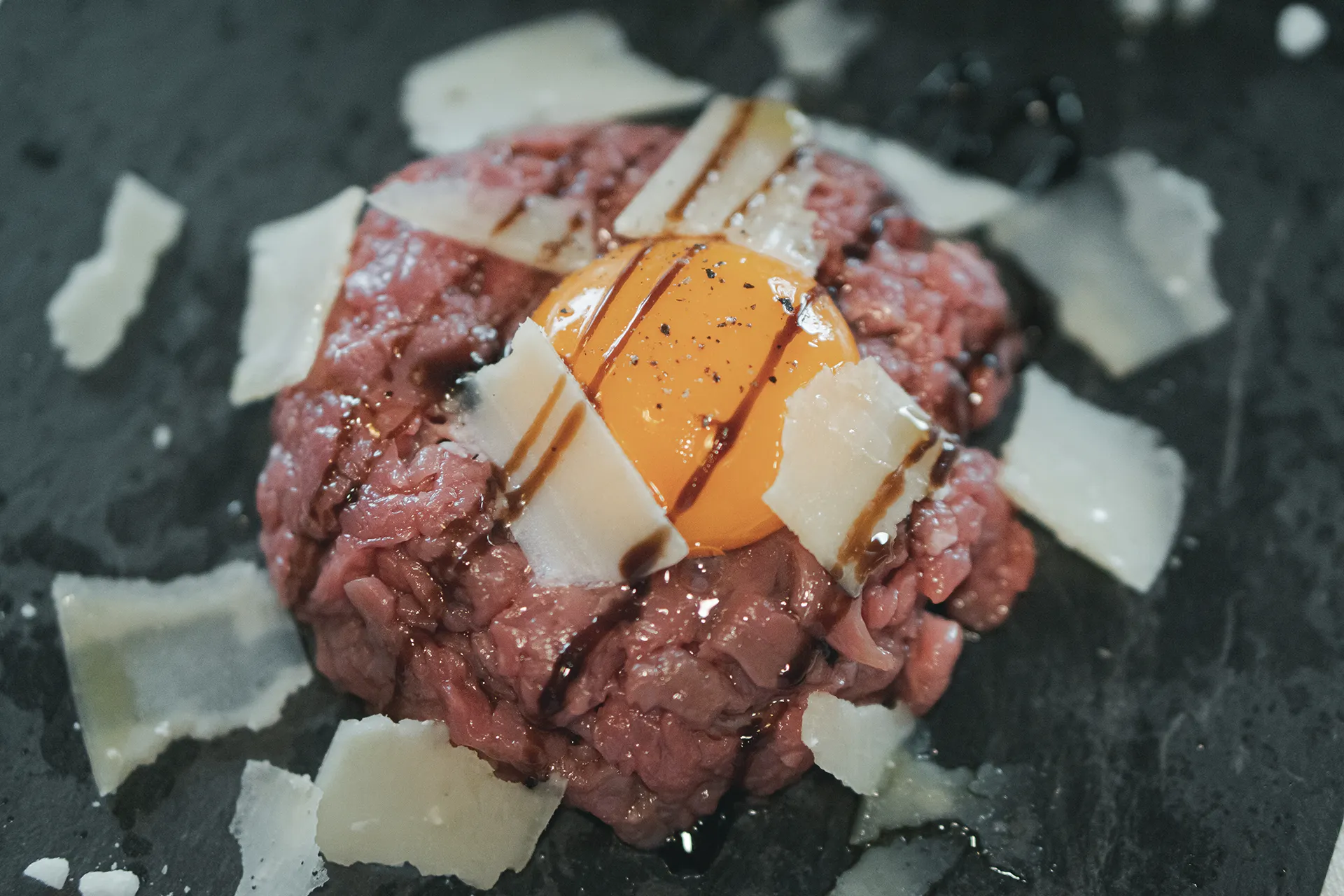 Tartarre di manzo con tuorlo d'uovo, scaglie di grana e pepe